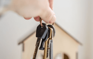A person is holding keys for a new home