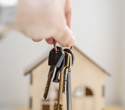 A person is holding keys for a new home