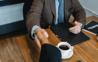 a credit restoration expert shaking a small business owner's hand